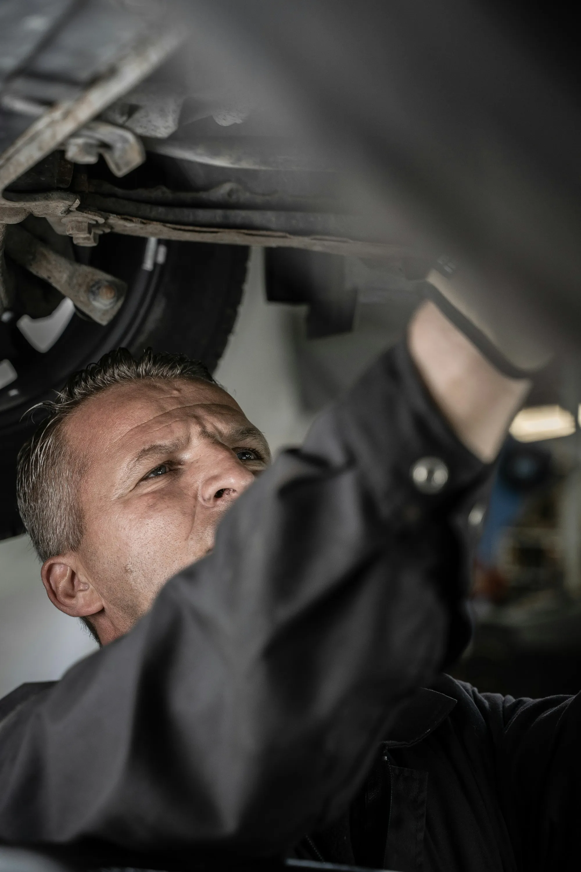 Mechanic working underneath a car raised on a lift