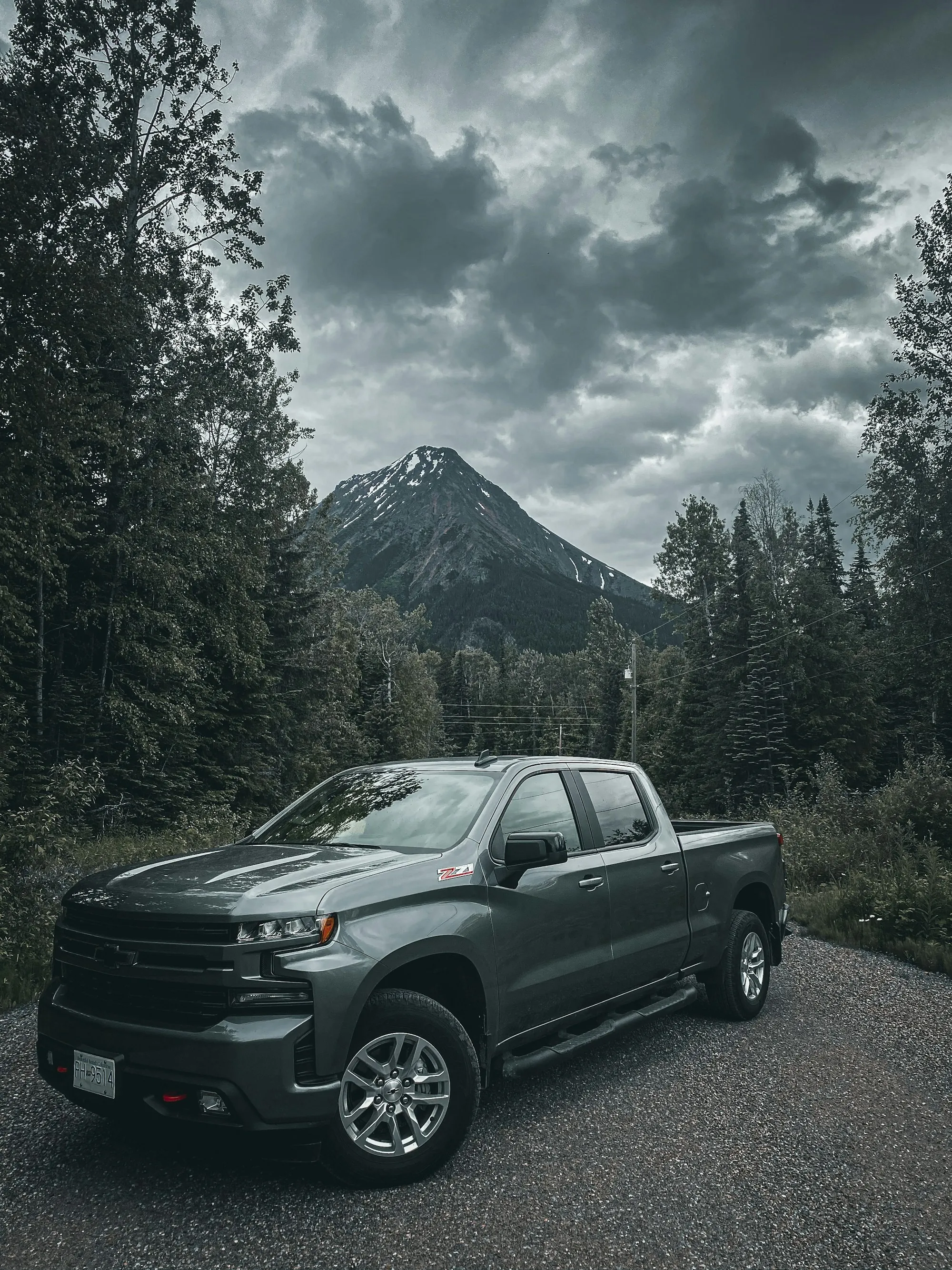 Dark pickup truck parked on a forest road in the mountains